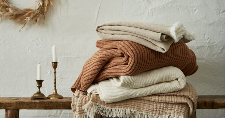 a stack of the brand’s soft, textural blankets and throws in neutral, wa 22