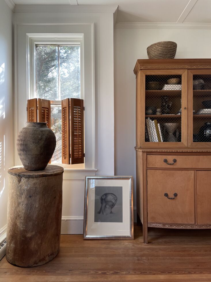 an old urn (scored on \1stdibs) sits atop an old hollowed out piece of wood tha 18