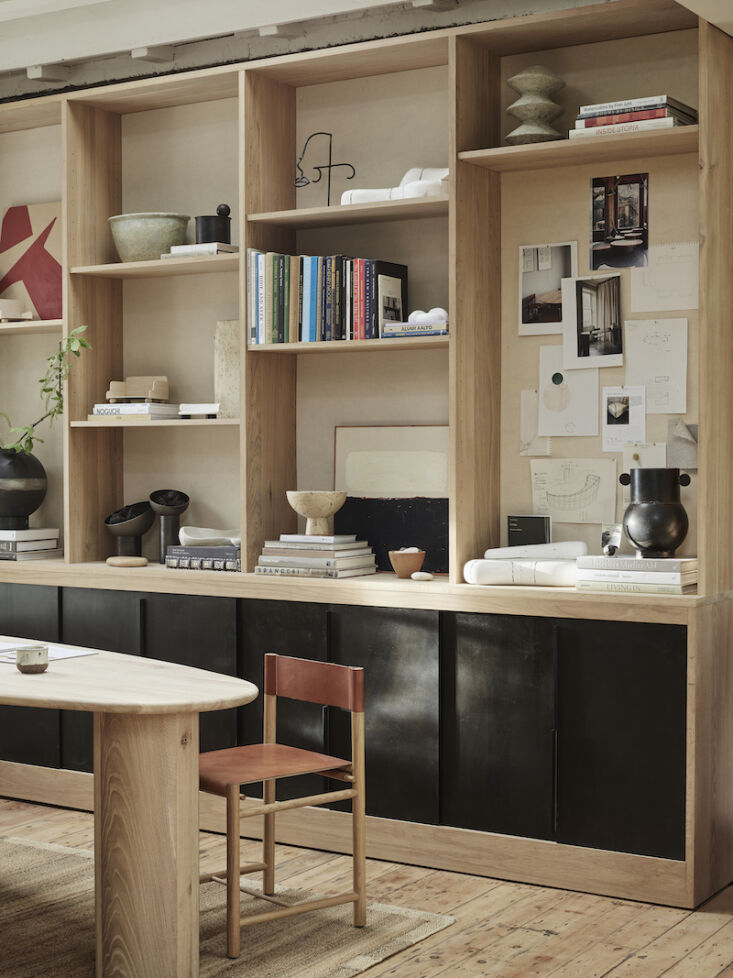 the showroom meeting and library space featuring a raw finished pebble table an 16