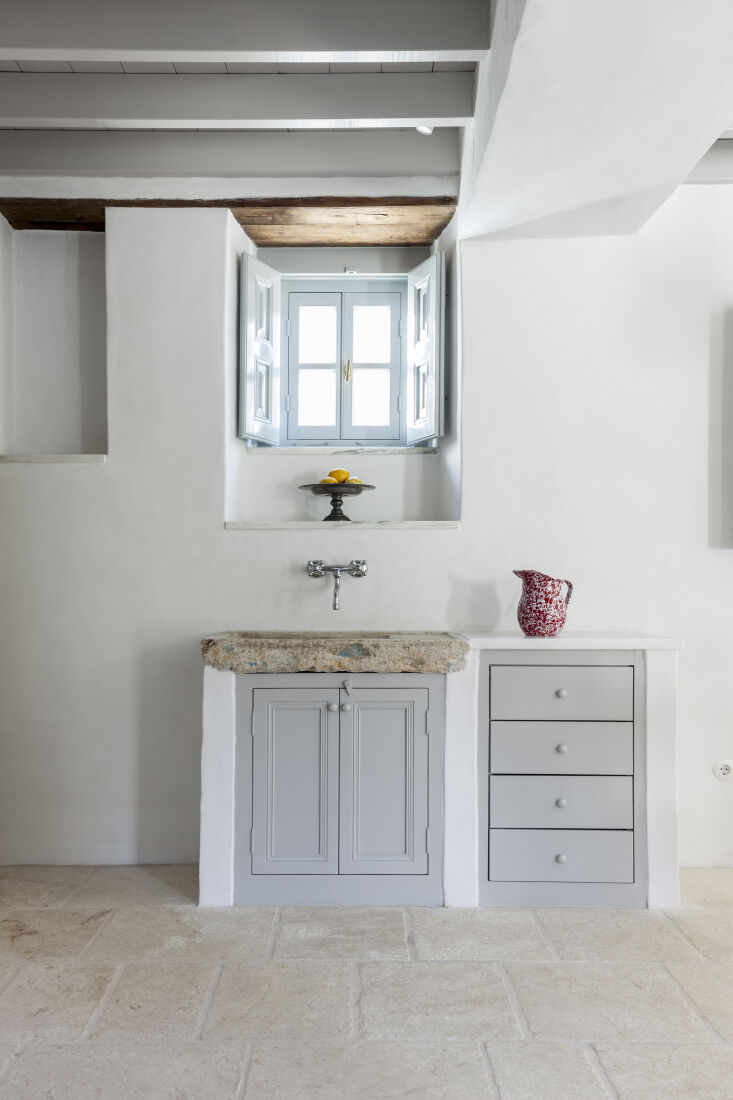 the stone kitchen sink is paired with a wall mounted faucet. the spatterware ju 23