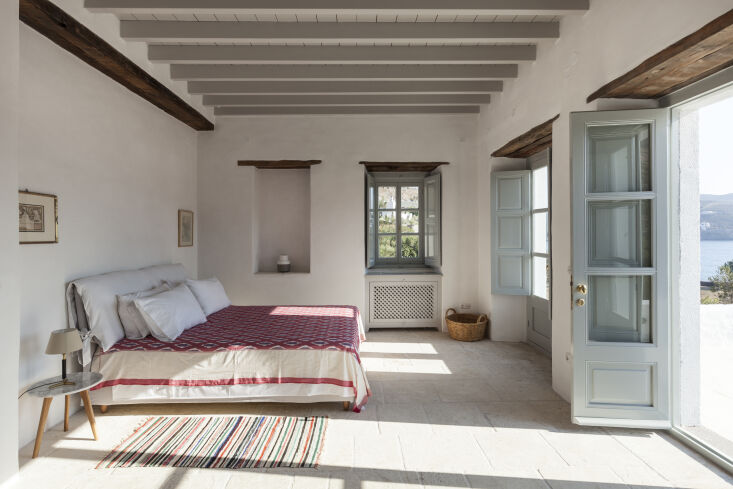 the bedroom gets its color from antique rugs and a locally woven textile as a b 26