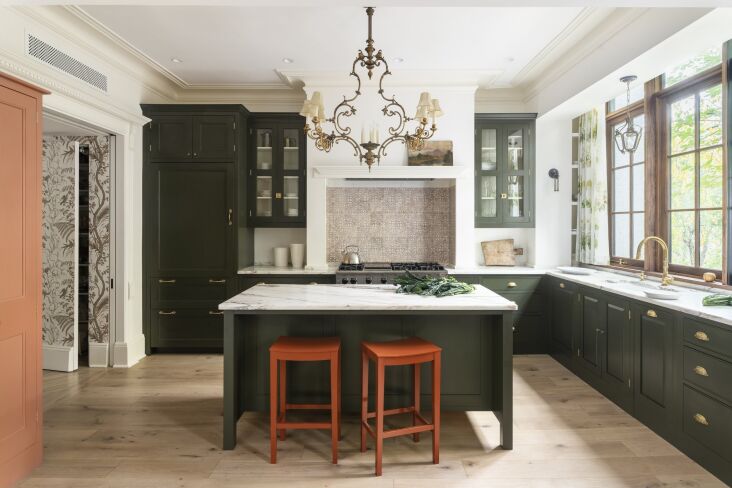 a view of the dynamic kitchen showcases standout red stools, brass hardware, an 17