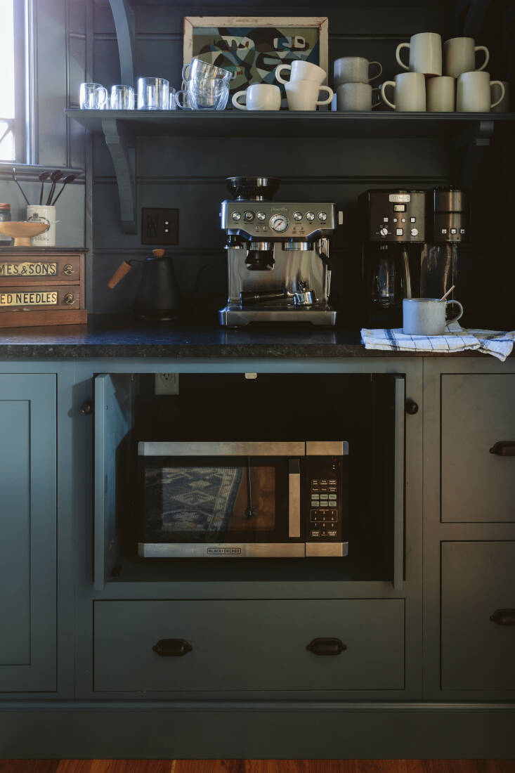 the microwave is kept on its own little built in shelf with retractable doors.  25