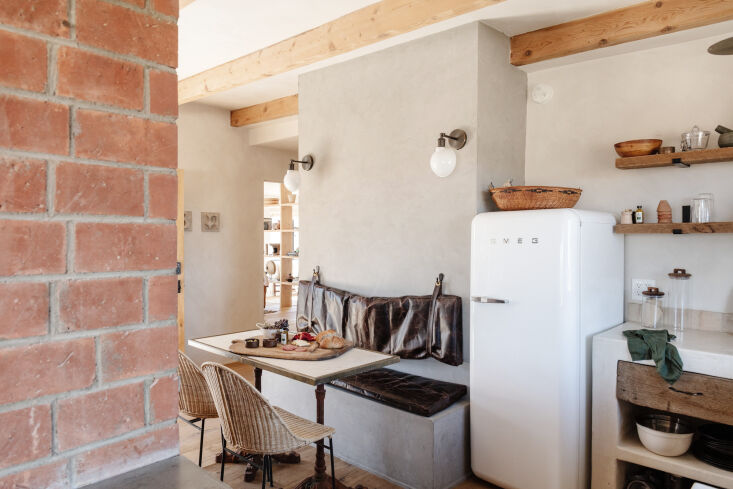 the couple nestled a \24 inch smeg refrigerator next to the space saving banque 19