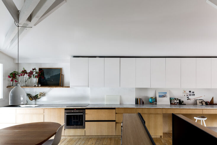 with a wall to wall carrara marble counter, the kitchen flows seamlessly into t 17