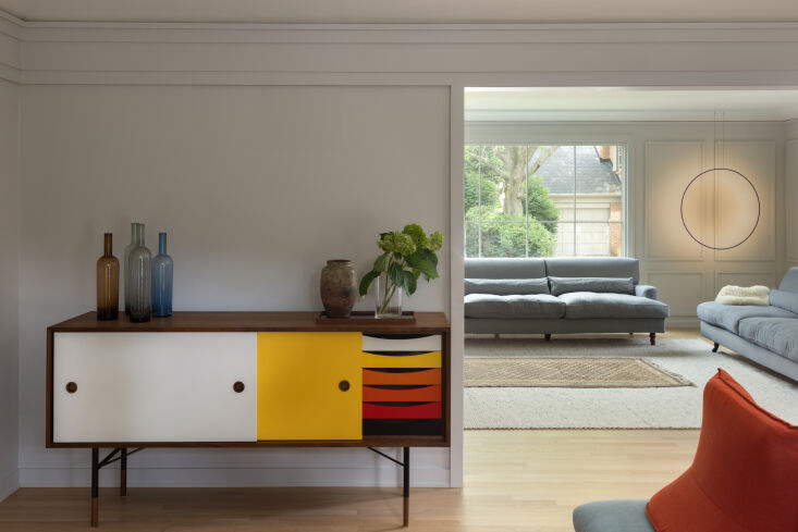 a finn juhl sideboard, a \1955 design still in production, stands in the den, w 19