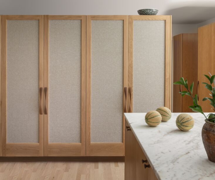 the dining room cabinets are inset with a textured fabric as a way to distingui 25