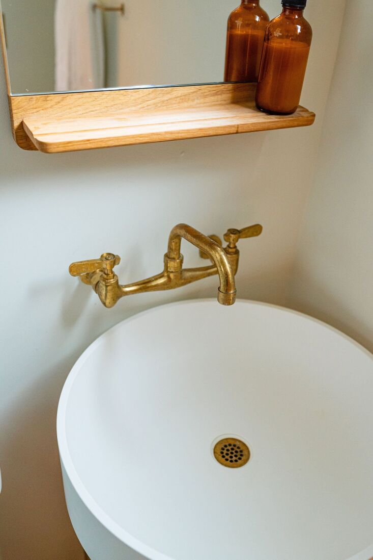 the bathroom\2\17;s bridge faucets in unlacquered brass were sourced fro 26