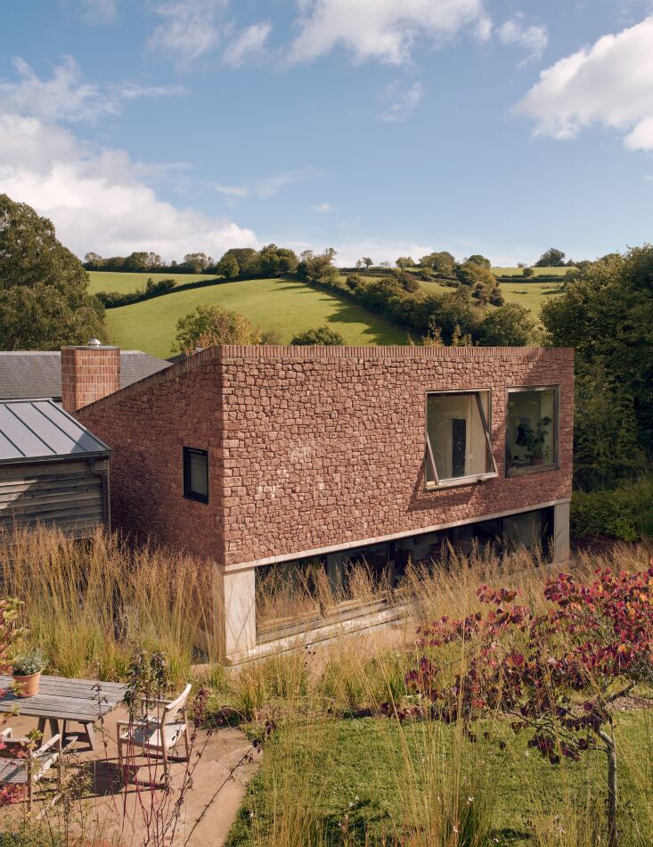 the central new building is clad in locally quarried pink sandstone edged with 17