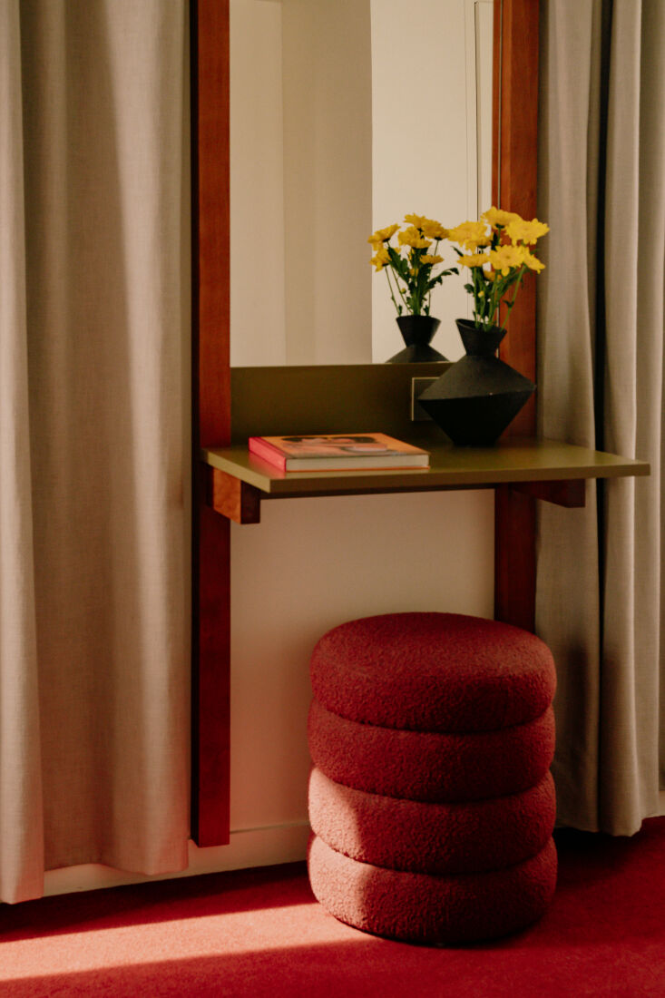 a tiered bouclé ottoman serves as a seat for the writing desk/vanity. 26