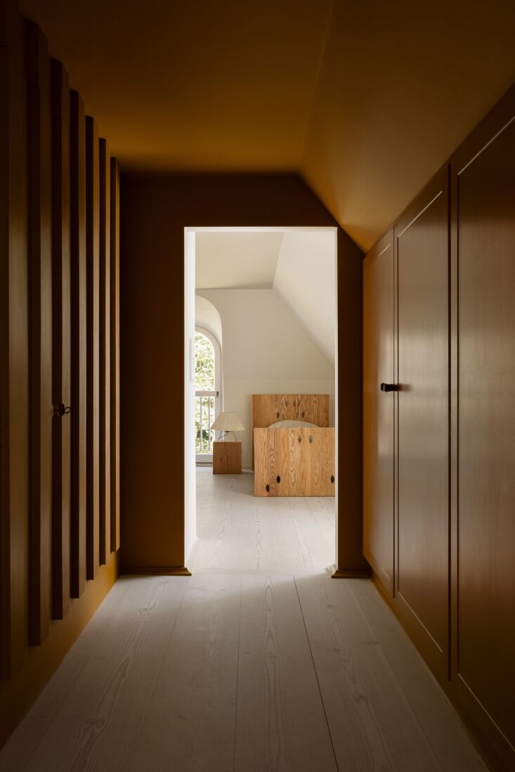 the hallway into guest spaces is coated in a deep ochre paint color (oxydbrun g 29