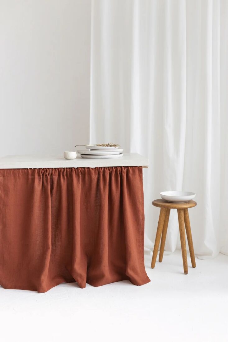 the deep coral pleated curtain that skirts the table is from london based loual 22