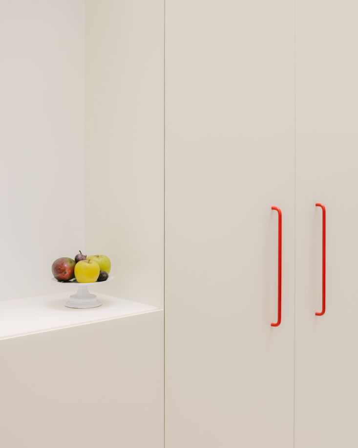 bespoke, elongated cabinet pulls in bright red are set in an irregular rhythm t 21