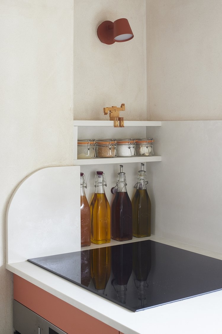 a storage niche is tucked alongside the neff induction cooktop. the red tip wal 21