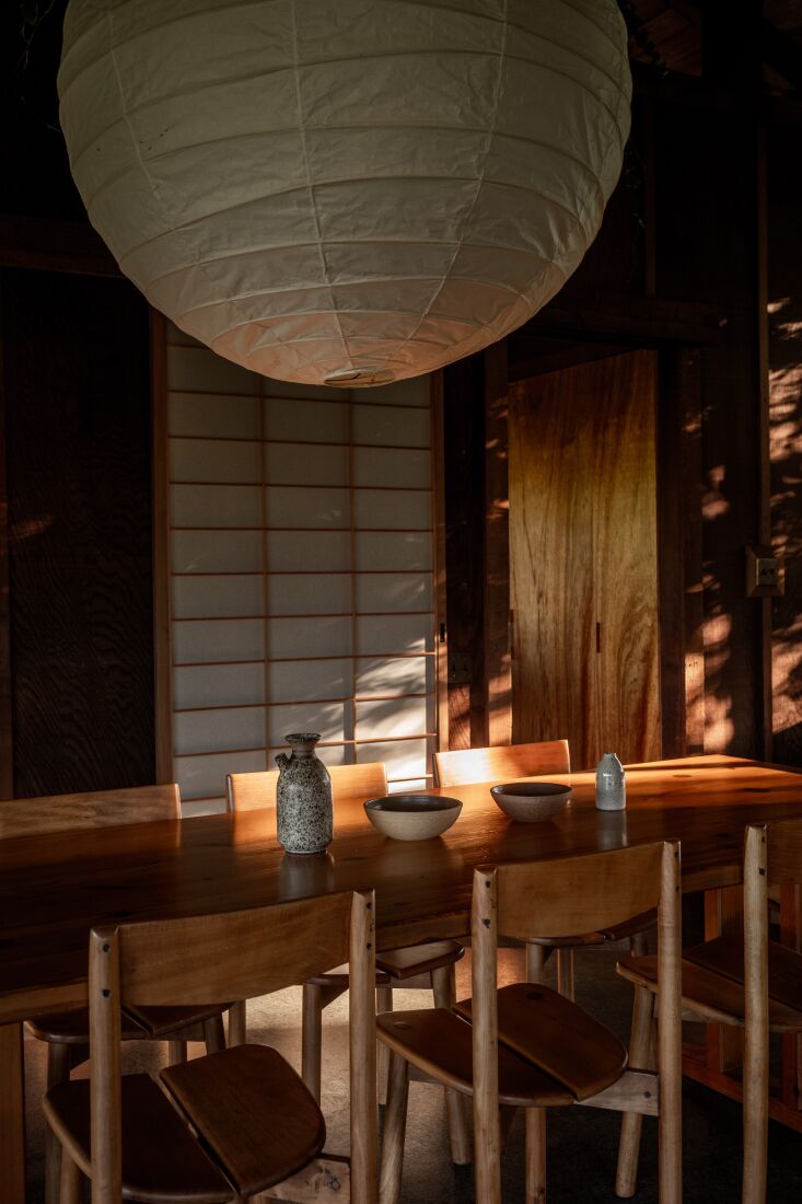 the dining room is anchored with a charlotte perriand dining table, pierre gaut 24