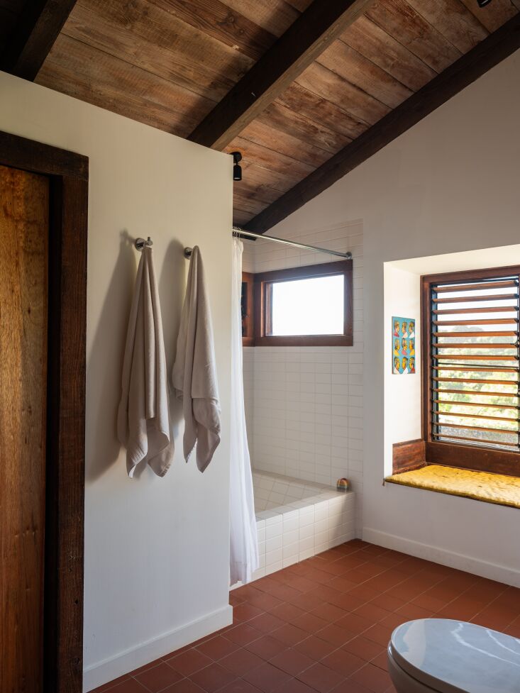 a view of contrasting tile with dark terracotta tile flooring. the bathtub is b 31
