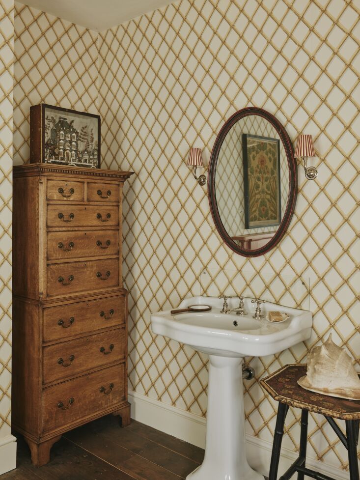 an antique chest on chest stands unobtrusively in a niche. the striped lampshad 27