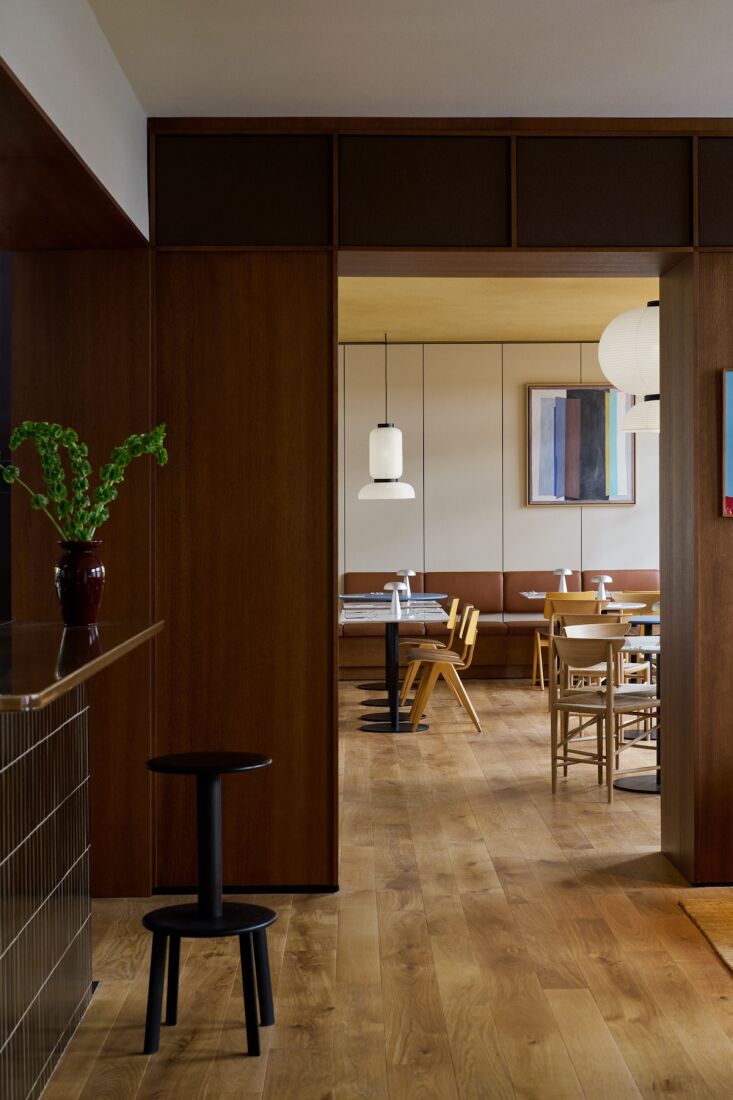 the lobby is compact and refined, clad in stained oak veneer with views into pe 17