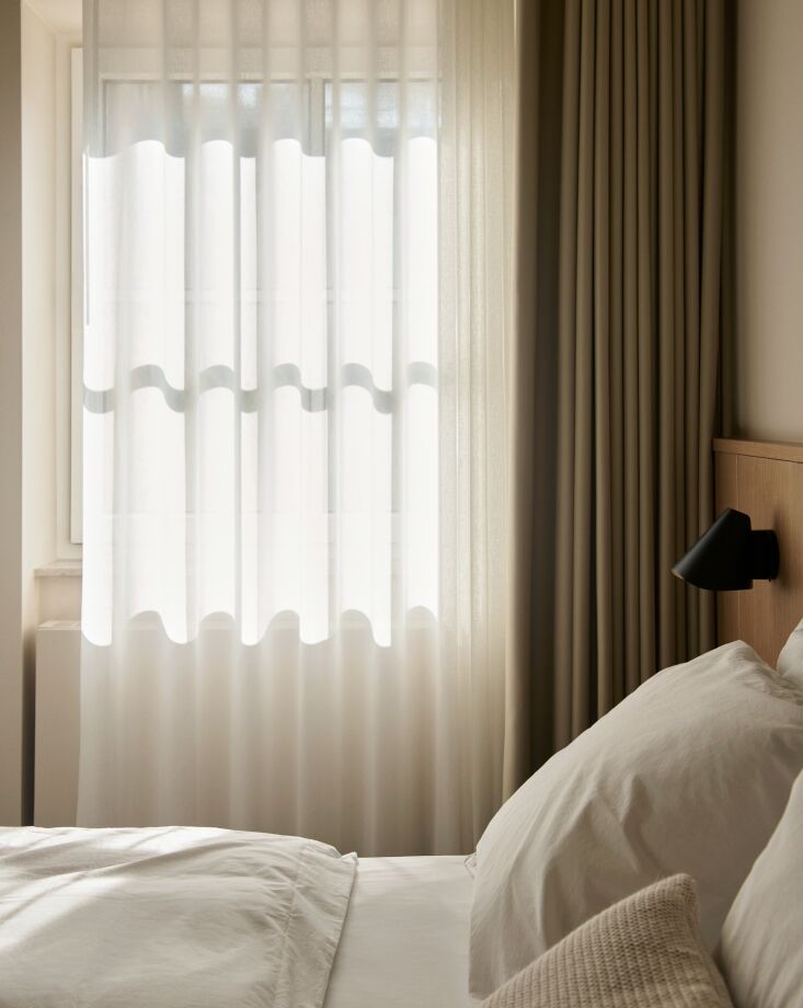 the window coverings combine sheer and wool curtains in layered textures. the t 26