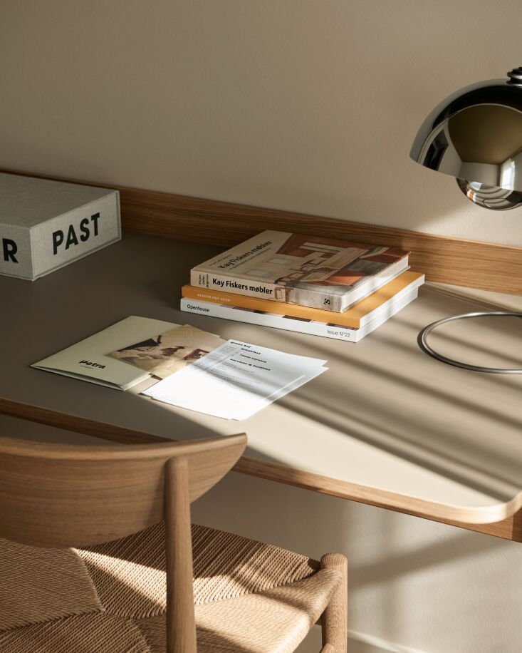 on the linoleum topped pavilion desk by anderssen & voll, a curated stack o 24