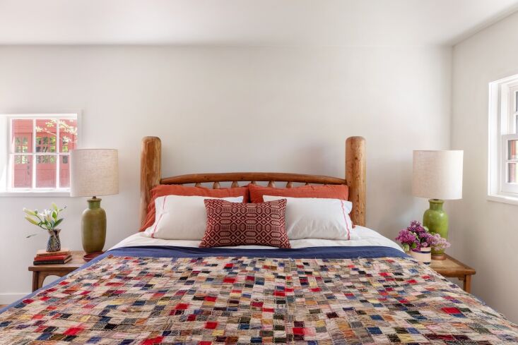 an antique patchwork quilt on a log bed. 35