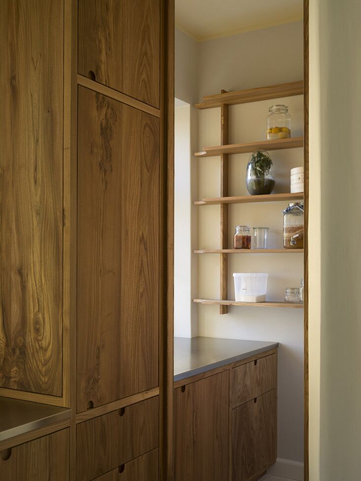 the pantry shelves are detached from the back wall to offer a lightness to the  19