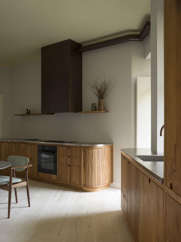 a custom range hood in burnished brass is made by gørtler metalsmeden. the mil 20