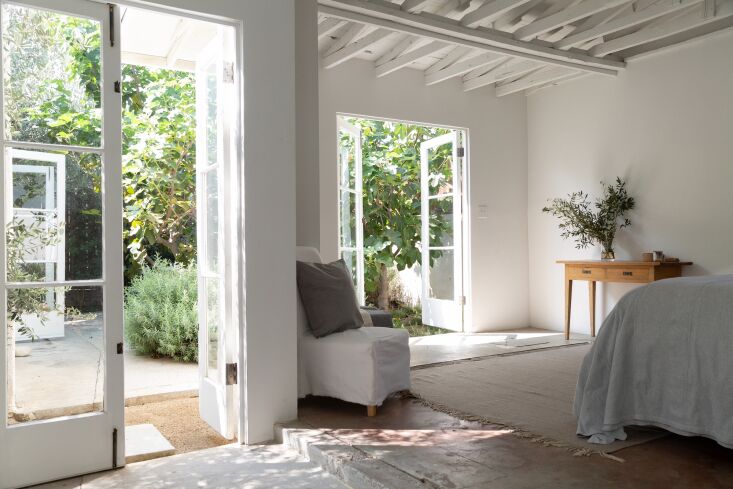 the primary bedroom, with two sets of french doors that lead to the courtyard.  26