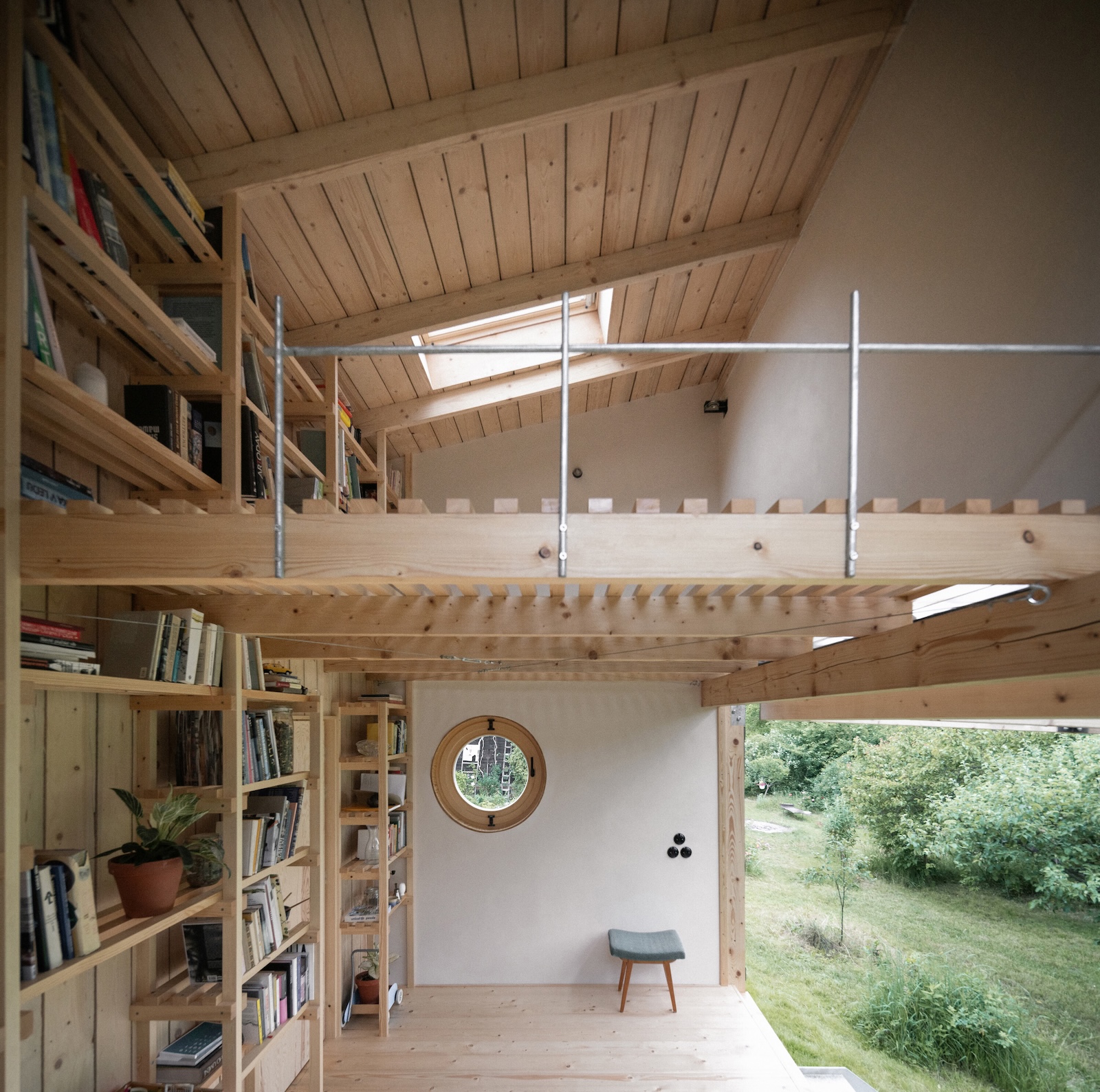 the bookshelves extend to the loft, which is used as a place to lounge and as a 21