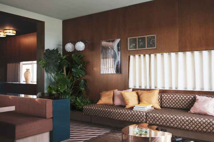 the living room is designed with wood paneling and a unique narrow rectangular 22