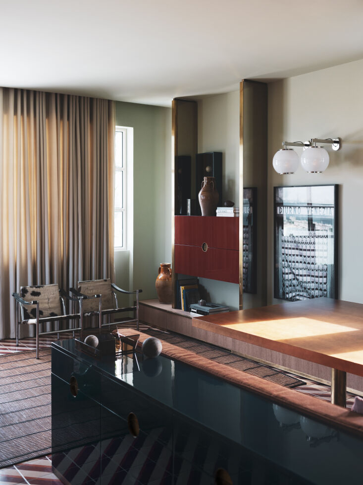 the living room is designed with an oversized tuareg rug and a pair of lc\1 le 21