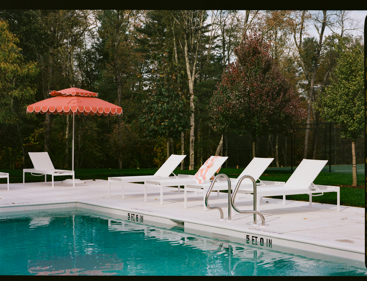 the pool and tennis courts stand alongside a pool house. photograph by cole wil 29