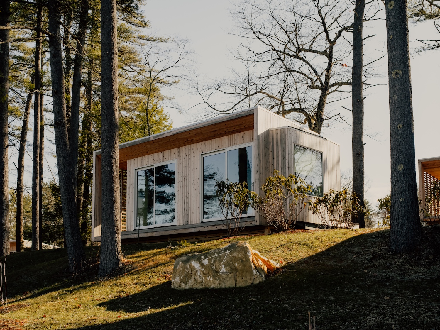 large windows and sliding glass doors frame lake and woodland views. photograph 19