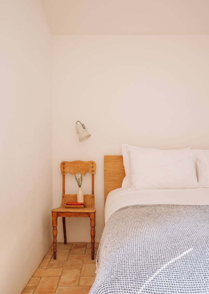 an antique chair serves as a bedside table. the cotton waffle ericeira blankets 26