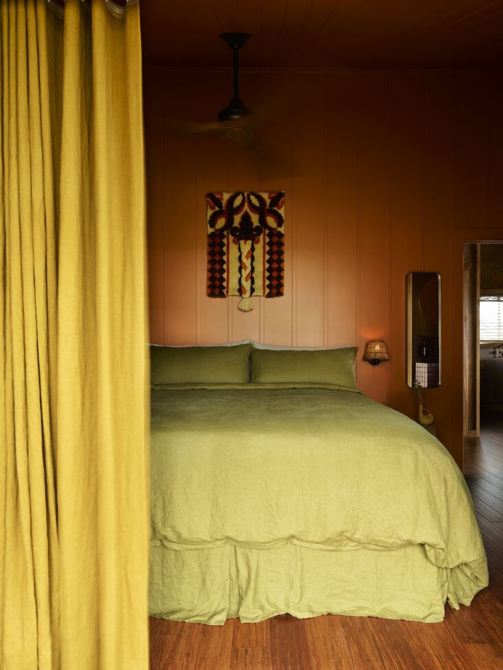 shades of terracotta, avocado, and golden yellow in a bedroom. the bedding is f 23