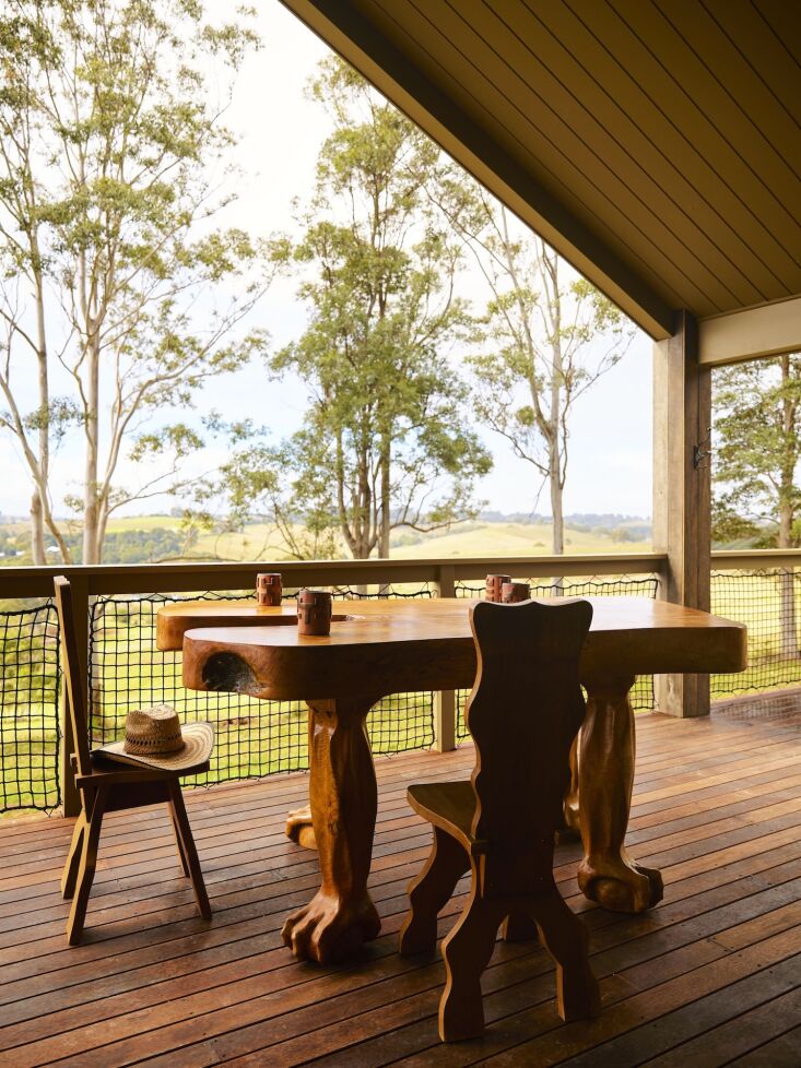 hand carved chairs and a claw footed table on a barn deck. the furnishings thro 22