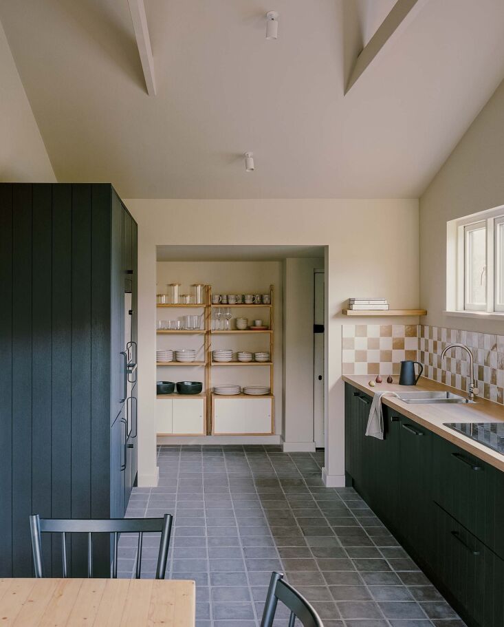 a checkerboard backsplash frames a wood countertop and a gooseneck faucet. for 17