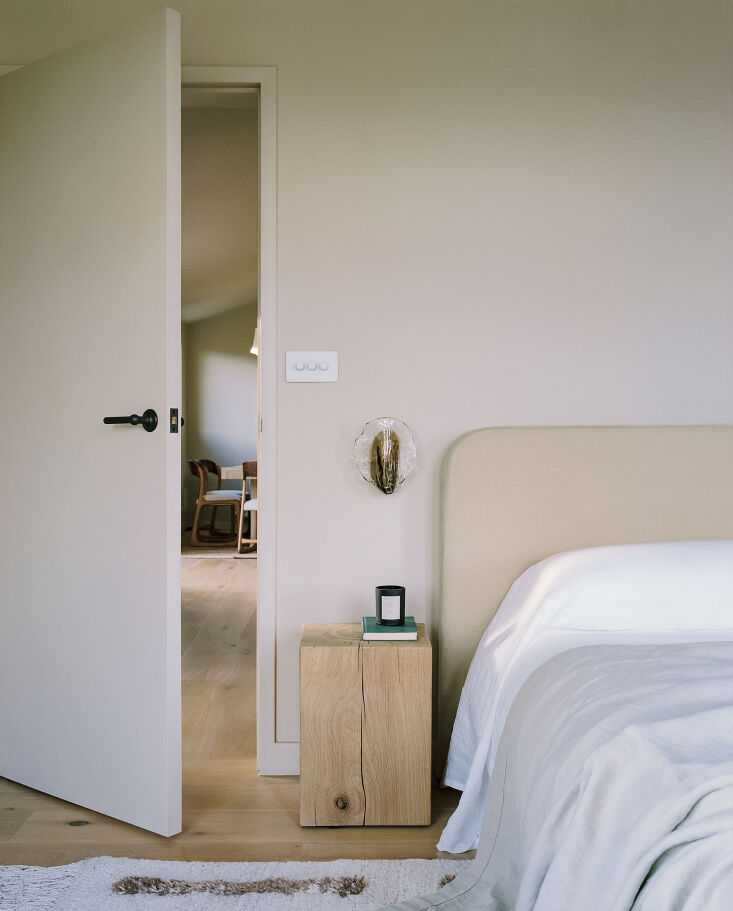 a serene bedroom with a custom fabric finished headboard, a wood block side tab 22