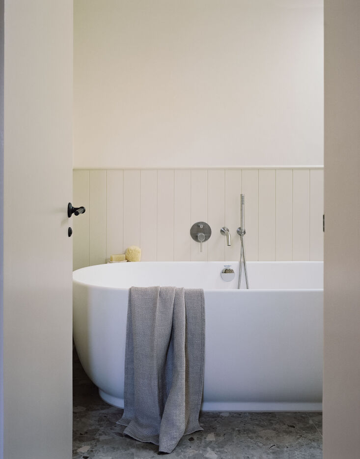 the bathroom features contrast wainscoting, a duravit luv freestanding bath des 23