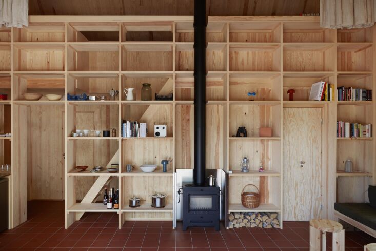 a large bookshelf serves as a room divider between the main kitchen living area 22