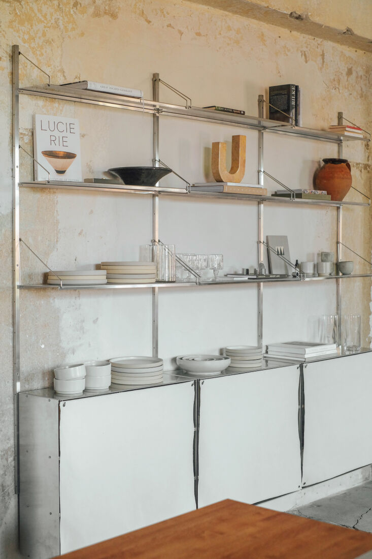 stainless steel wall shelves by frama hold dishes and glassware. 22