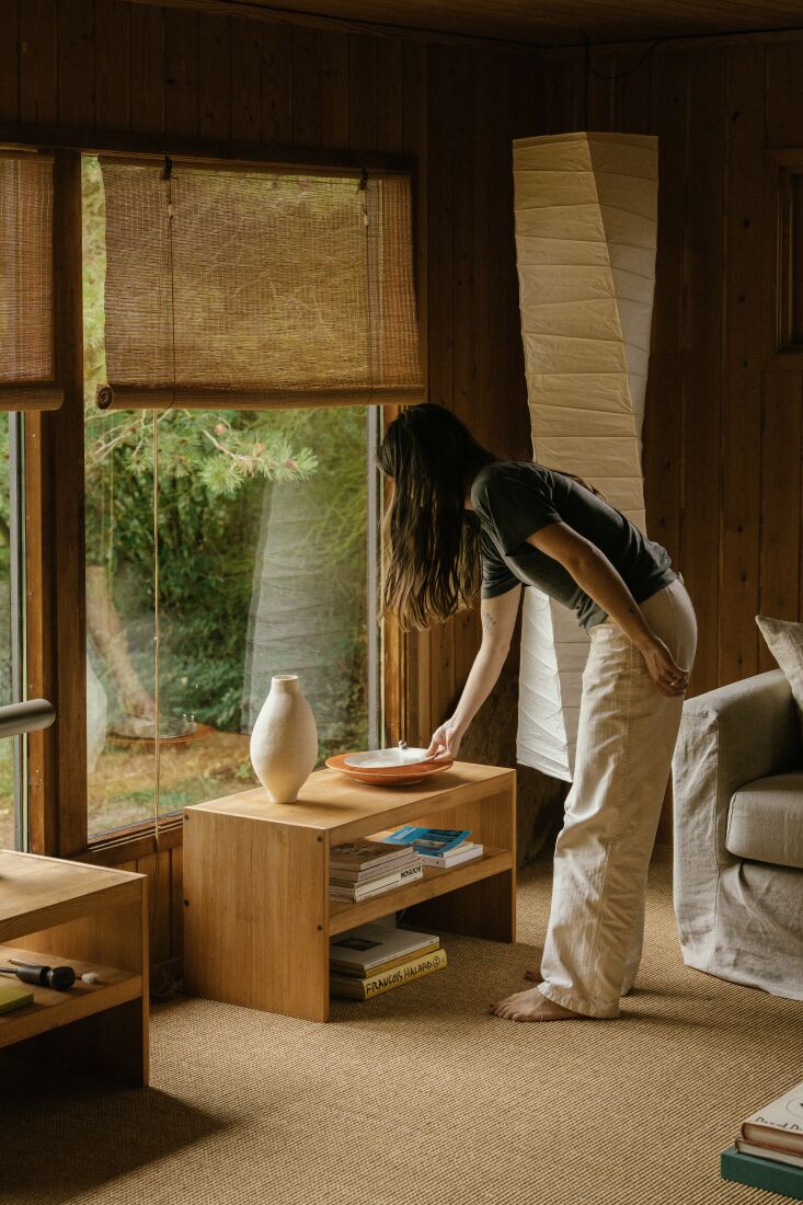 kasia moves tabletop elements around in the living room. much of the pine furni 19