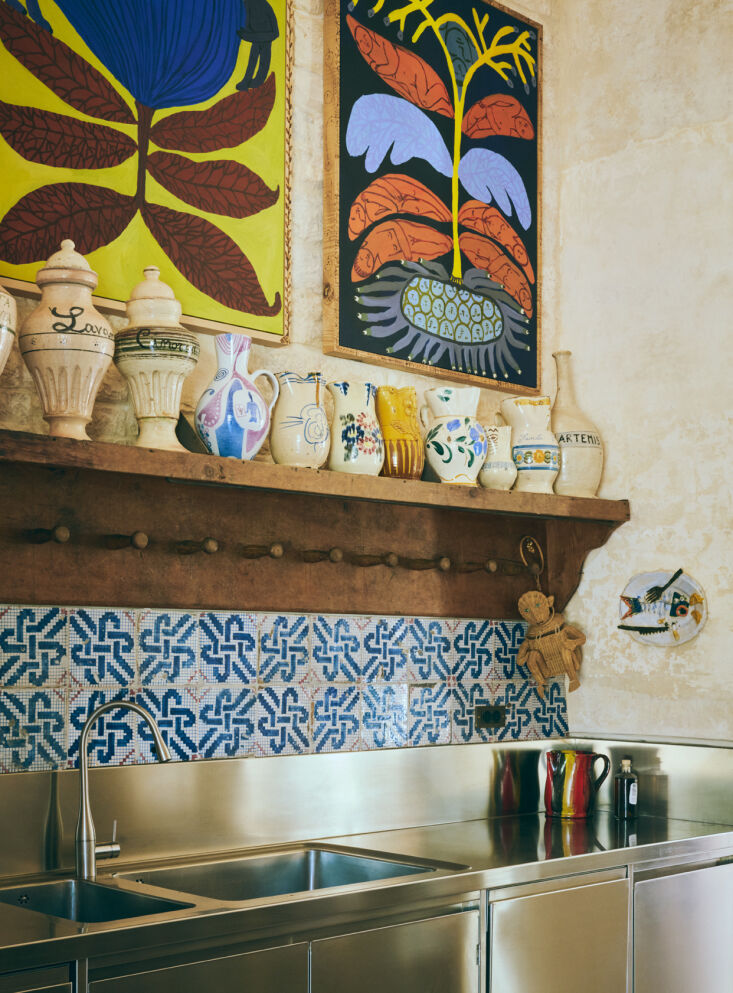 over the all stainless sink, a lineup of vintage ceramic vessels and two emma k 23
