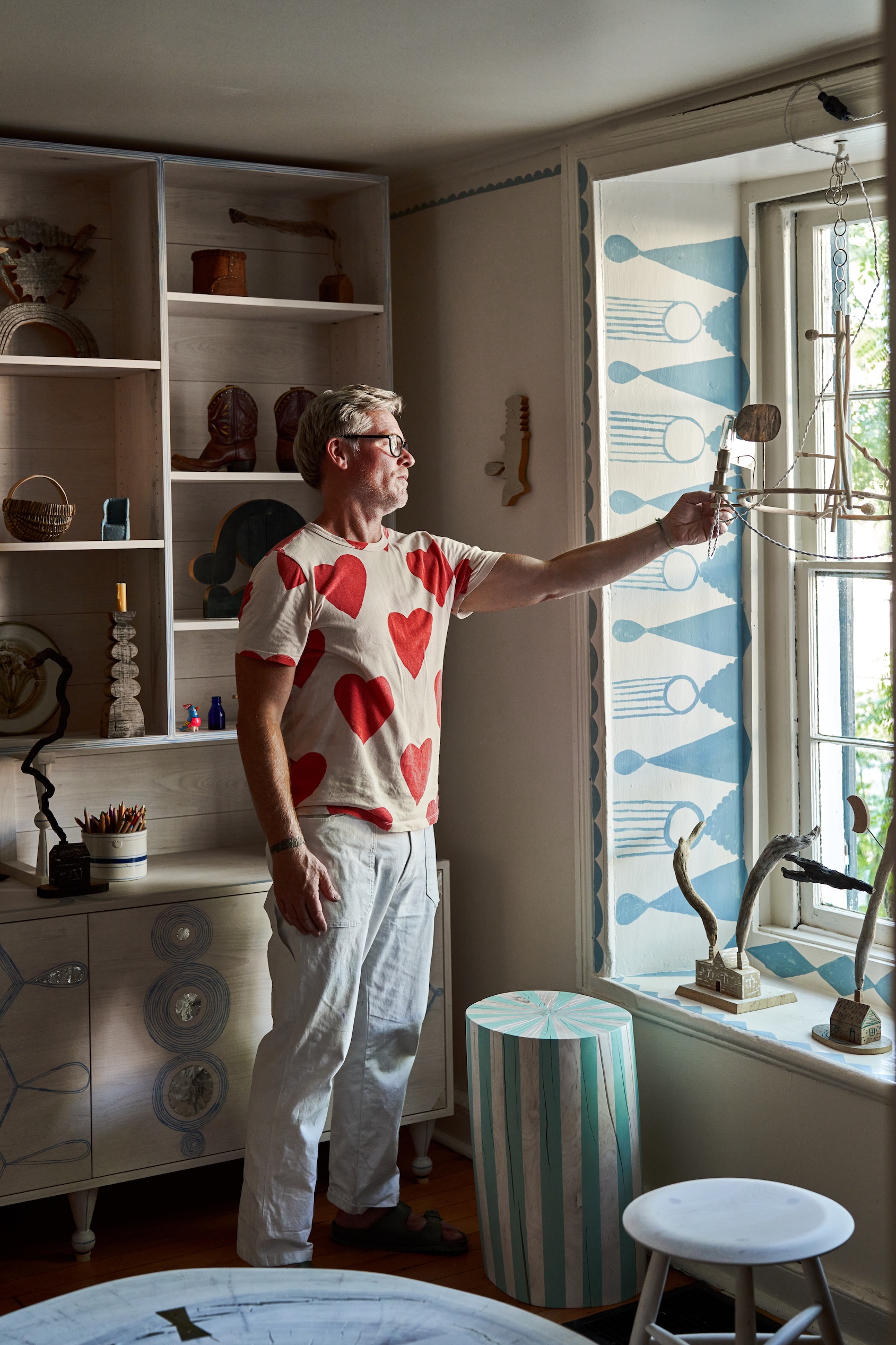 jonah, shown positioning a rousseau chandelier that he made from found branches 20