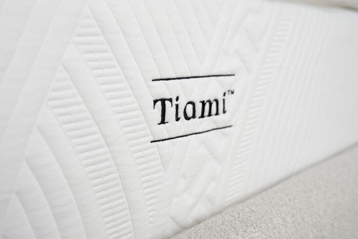 the tiami luxury hybrid mattress sits within the bed frame. made of layered mem 24