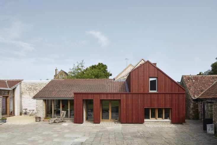 the clunky modern extension is newly integrated into the old stone courtyard, i 26