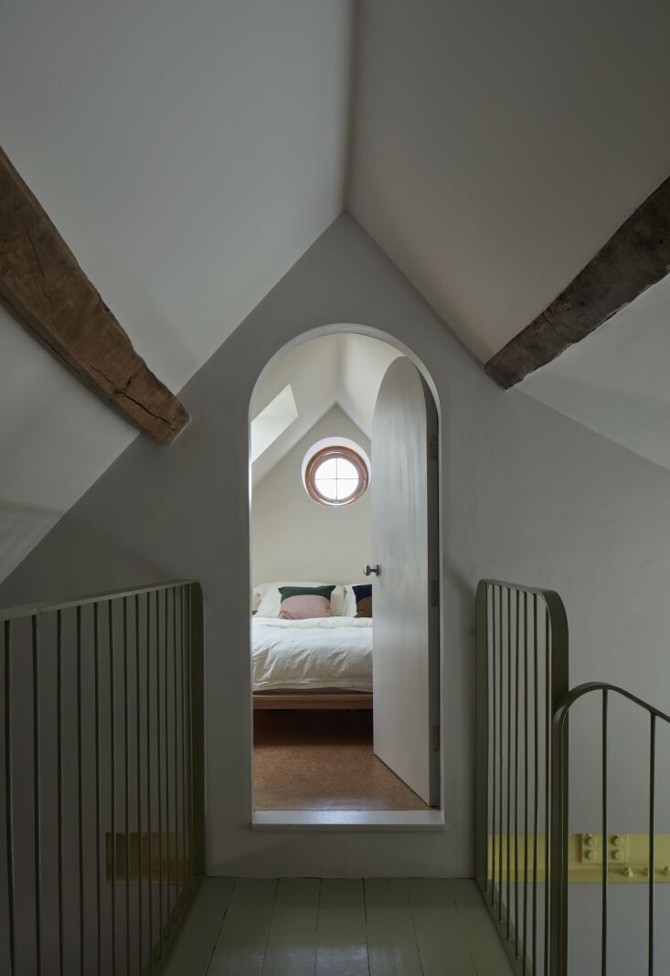 an attic bedroom with a porthole window. 24