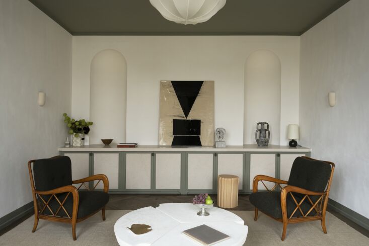 the living room is anchored with a codimat wool rug, vintage paolo buffa armcha 26