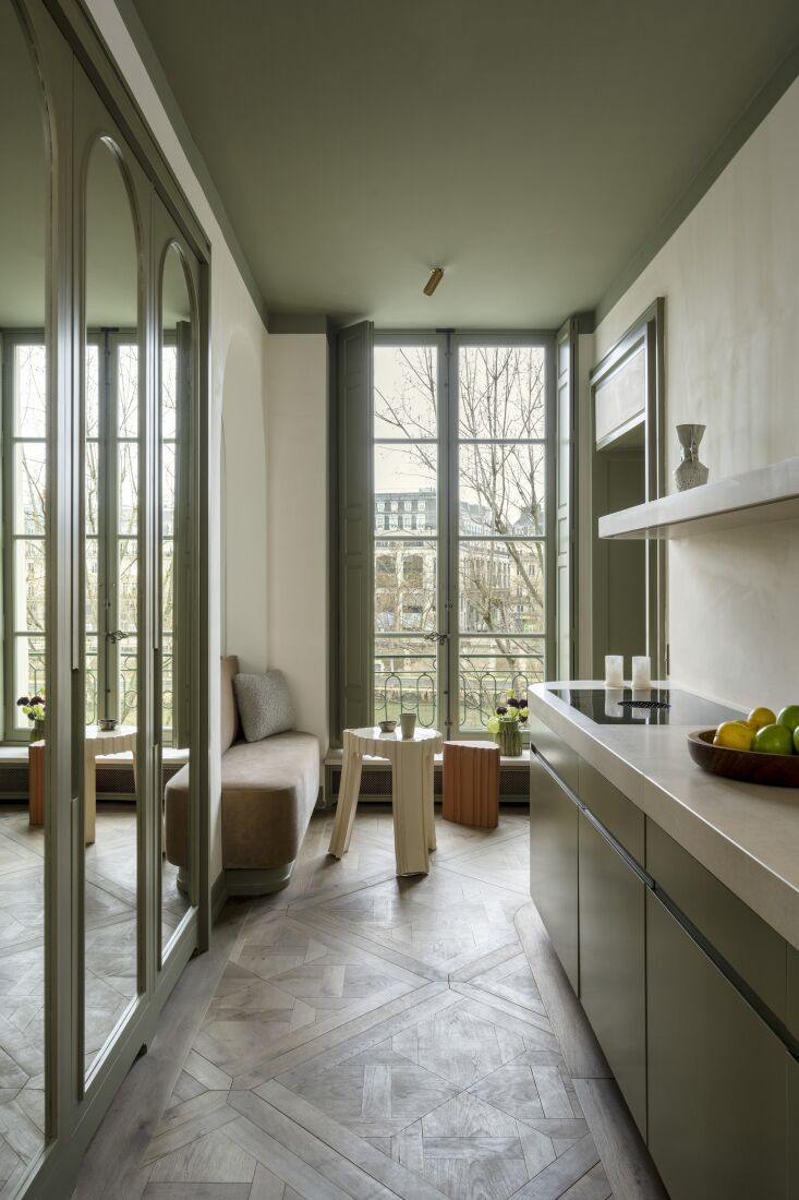 the kitchen is designed with custom wooden cabinetry finished in green lacquer  23