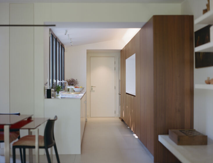 the kitchen was designed as a long piece of exotic wood furniture used to store 23